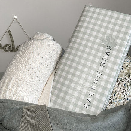 Checkered blanket with 'Ralphie Bear' branding on a bed