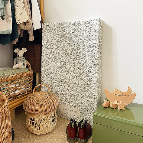 Children's room with patterned changing table, wicker basket, and wooden toys.