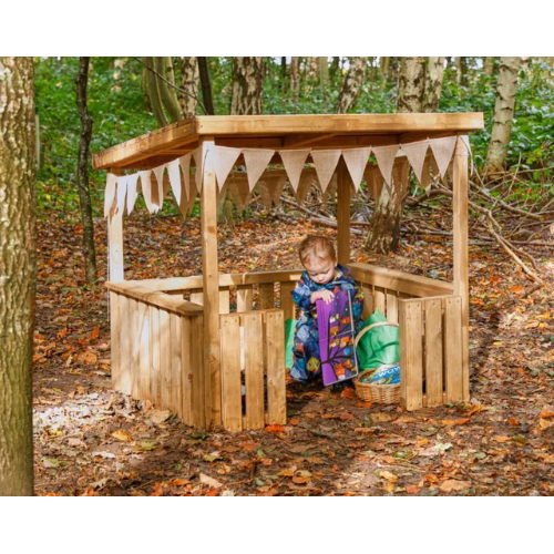 Child playing inside a wooden playhouse in a forest setting