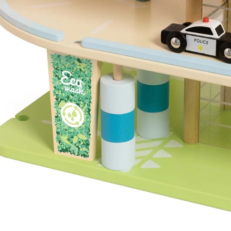 Children's playset with a police car and cylindrical objects on a green base.