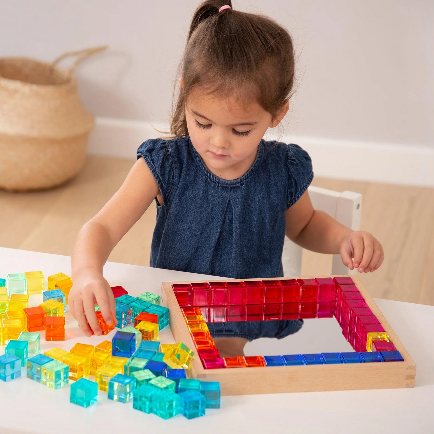 Child playing with colourful acrylic building blocks on a table