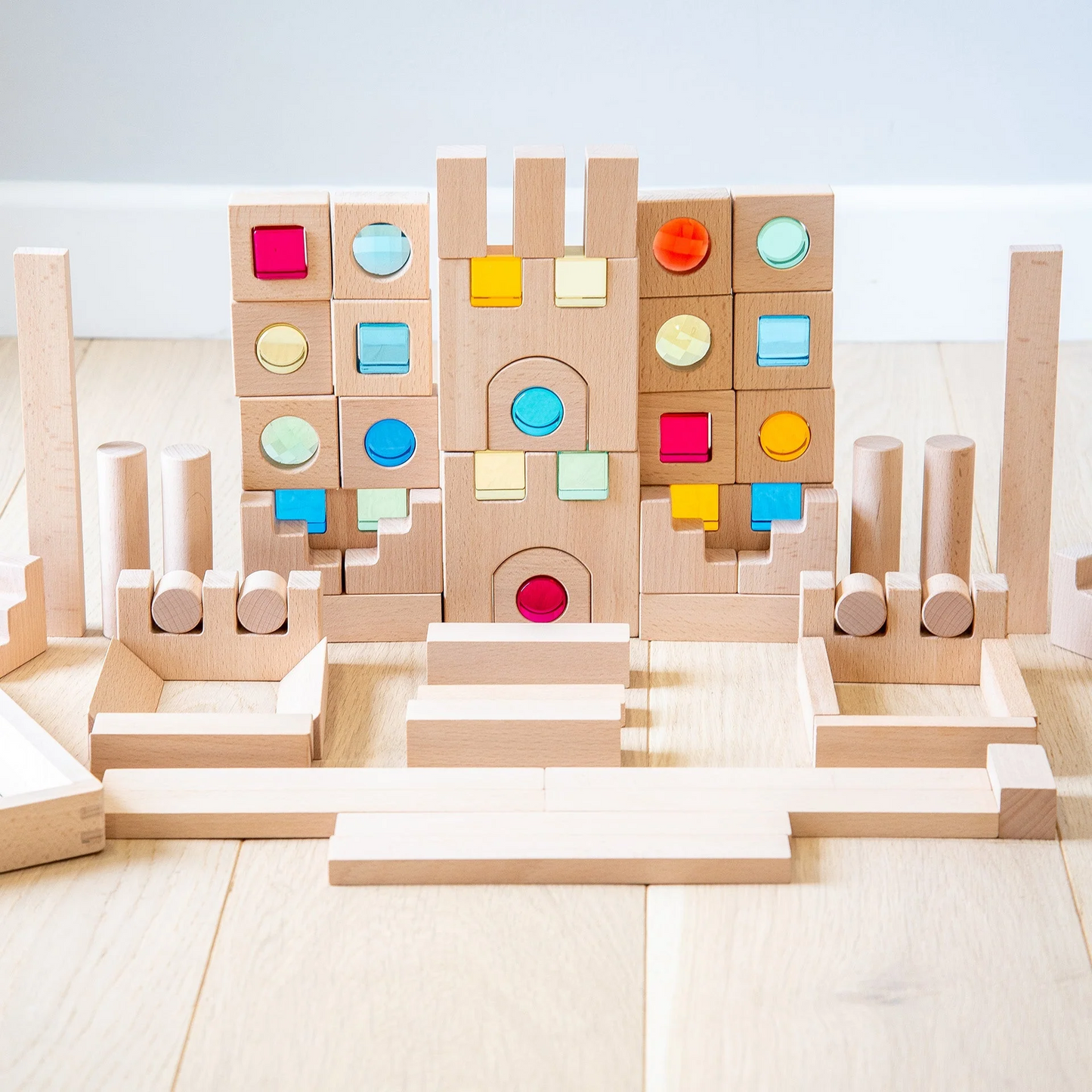 Colourful gem wooden building blocks on a light wooden floor