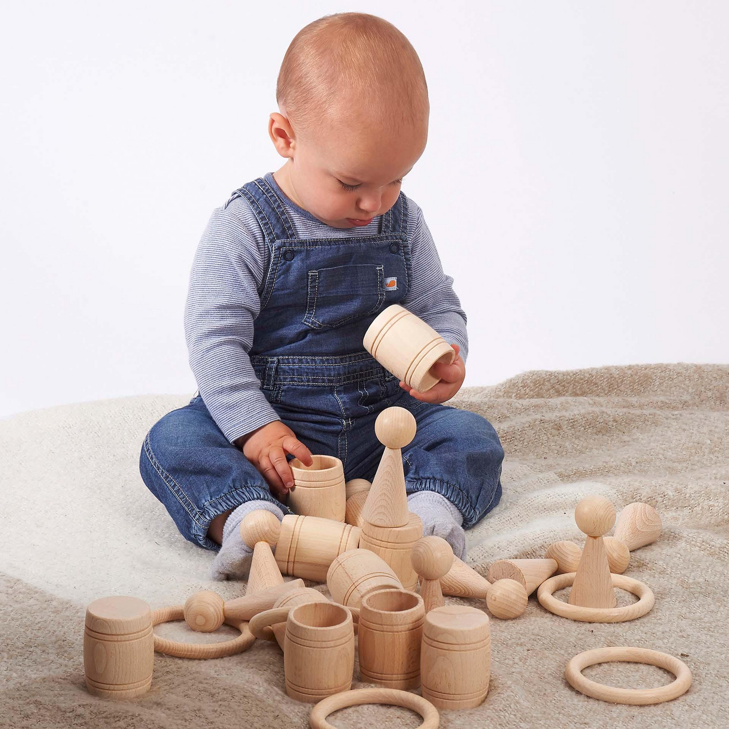 Child playing with wooden toys on a soft surface