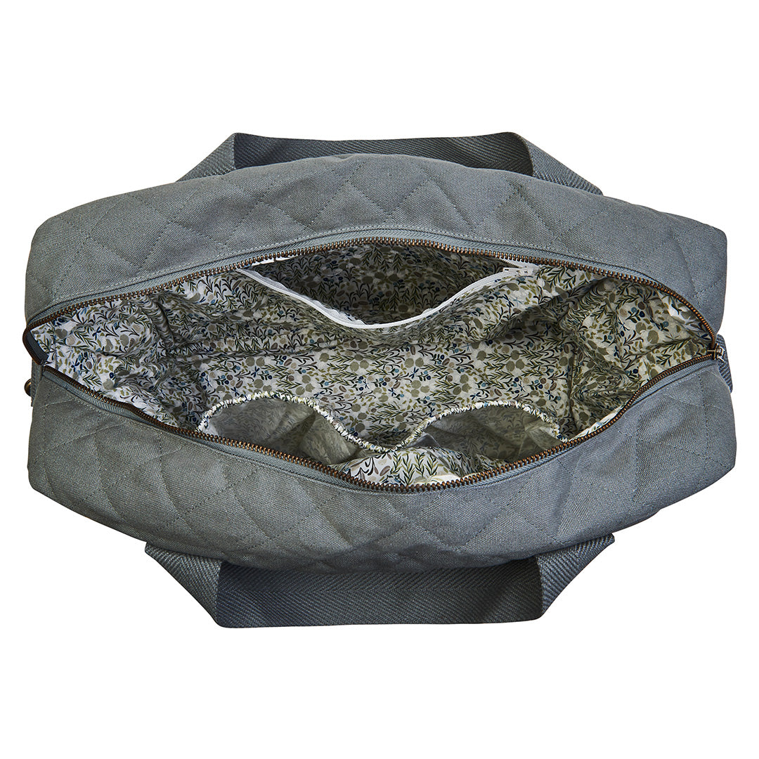 Gray quilted bag with floral interior lining on a white background