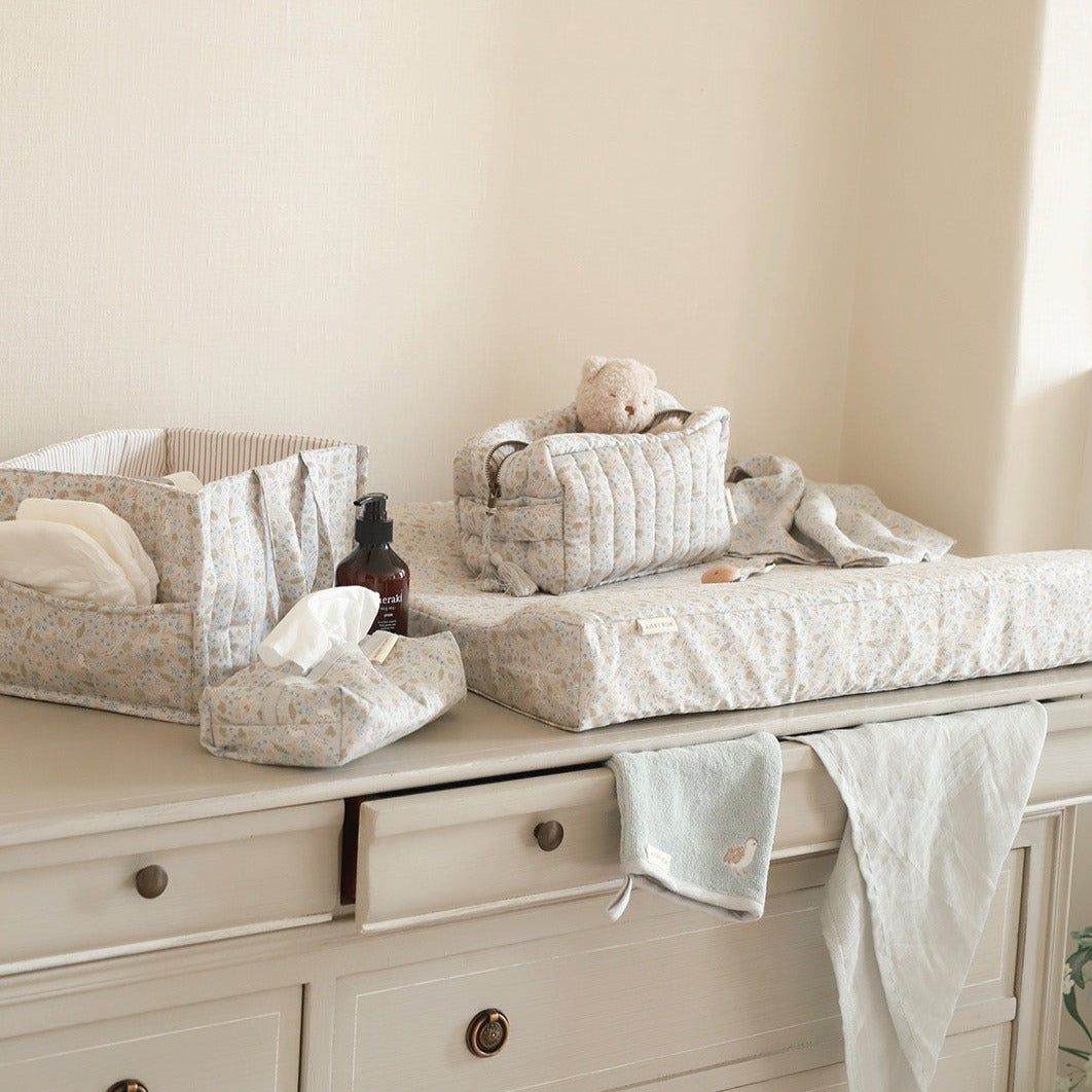 Baby changing table with baby items on a neutral background