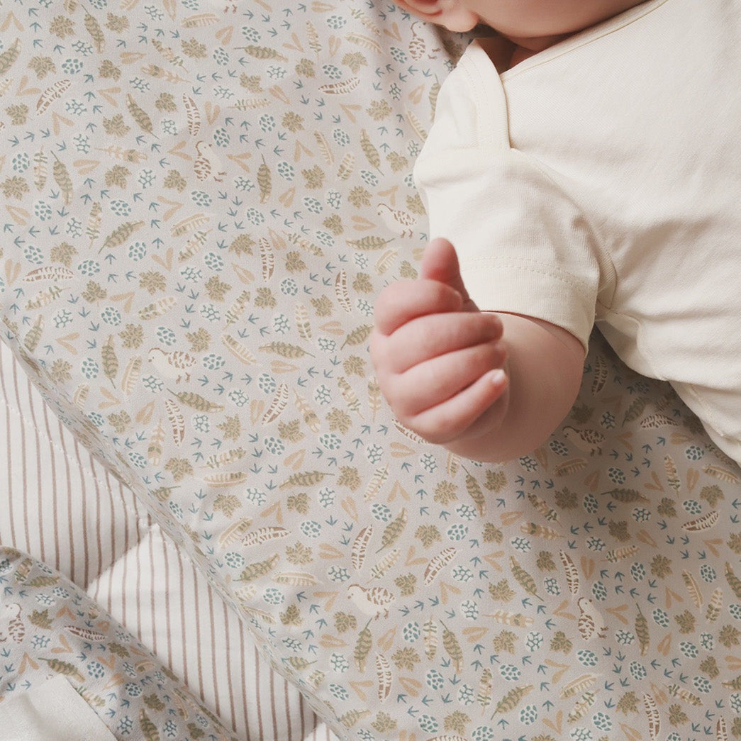 Baby's hand on a floral-patterned blanket