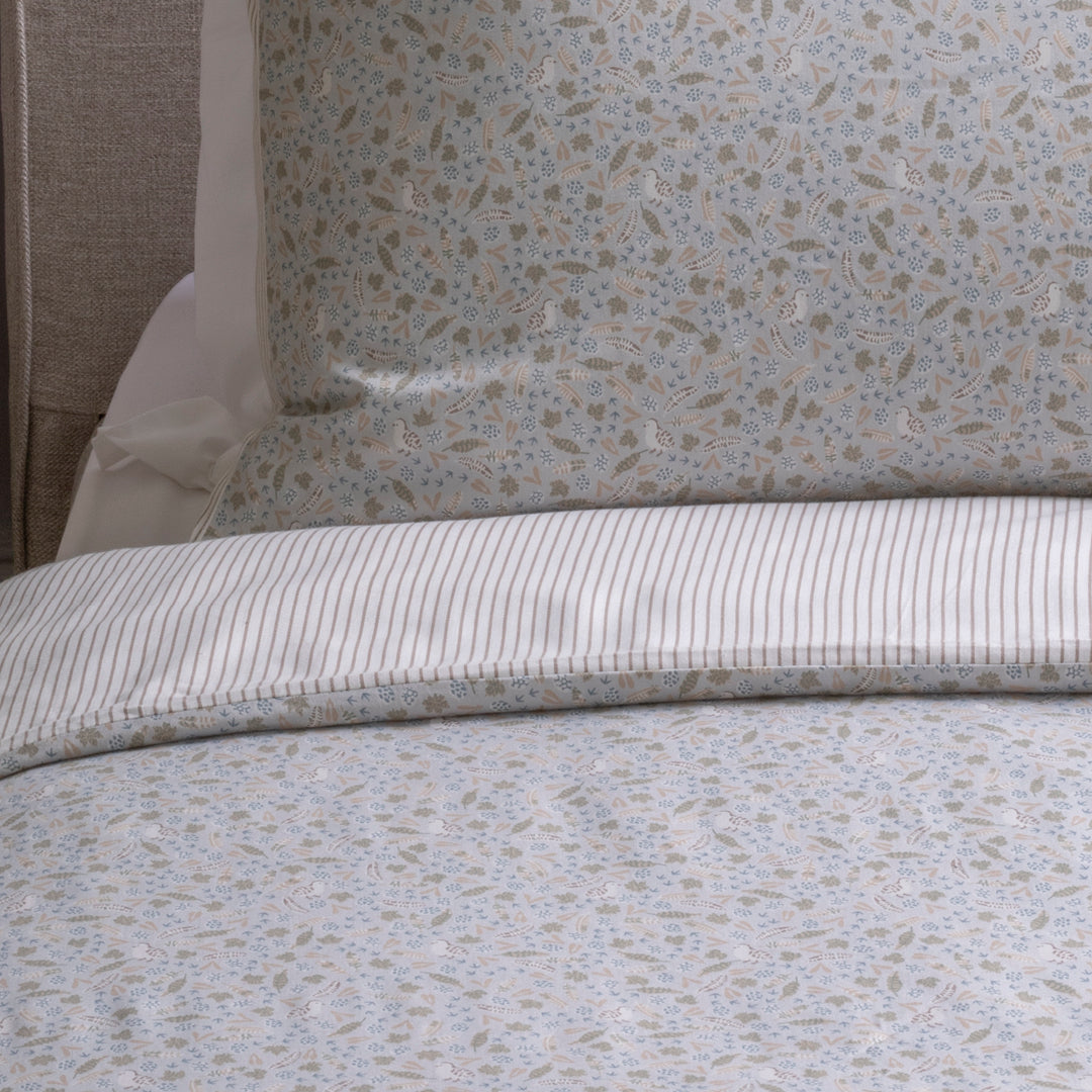 Close-up of patterned bedding with a floral design on a bed.