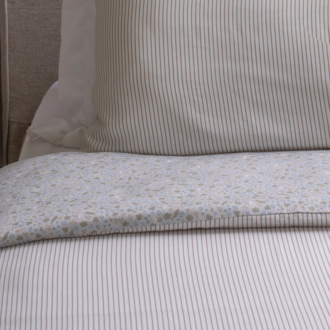 Close-up of a bed with striped bedding and a pillow