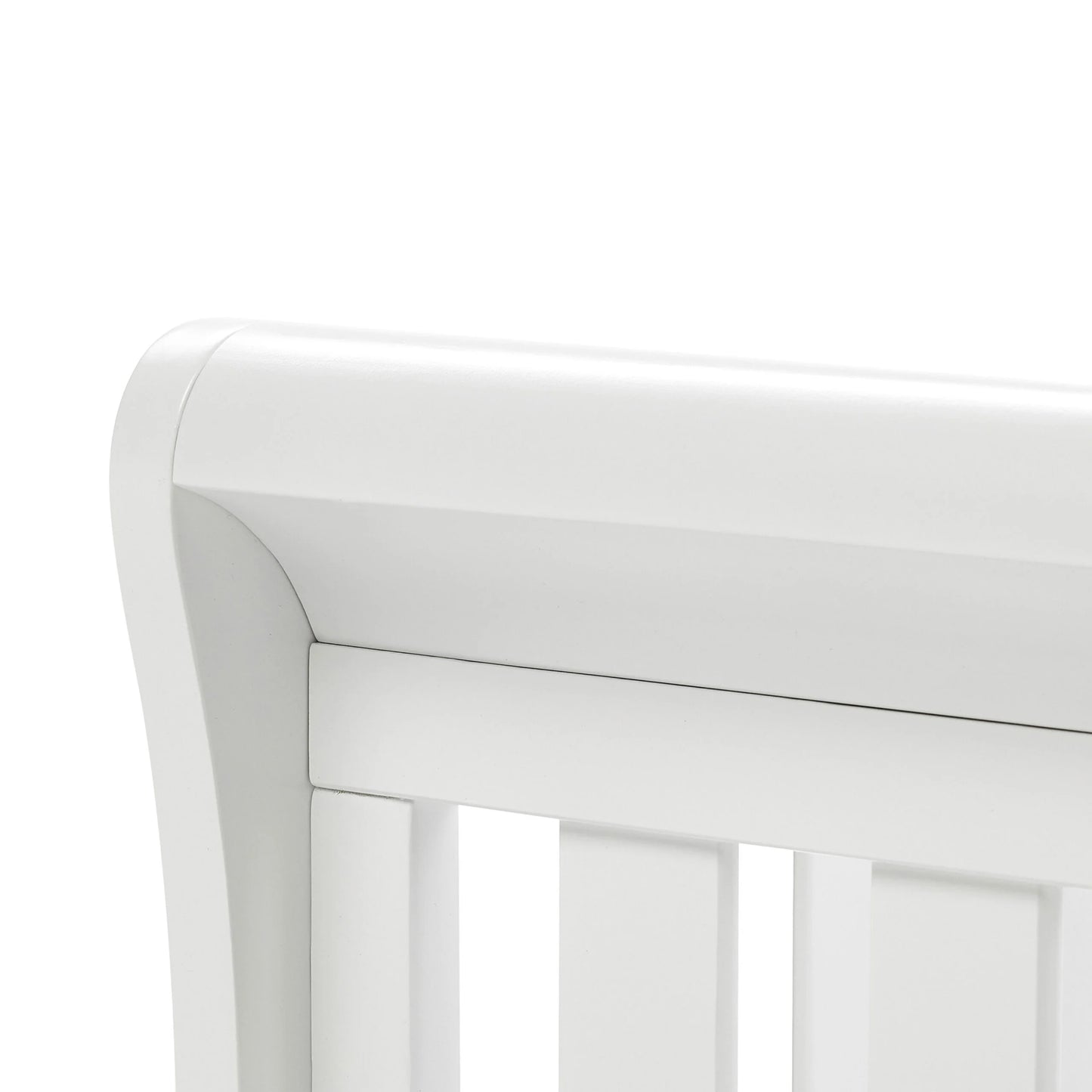 Close-up of a white crib with a blurred background
