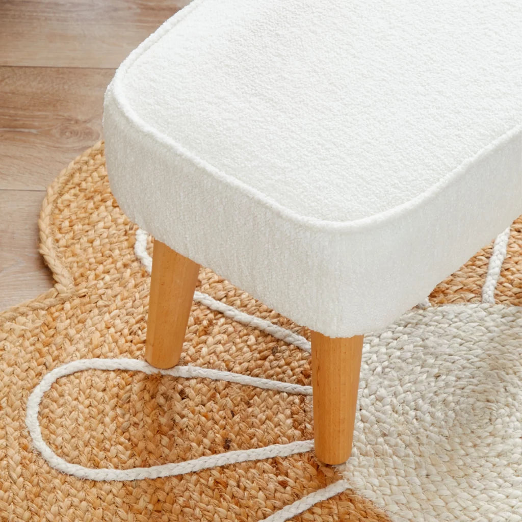 White stool with wooden legs on a textured rug
