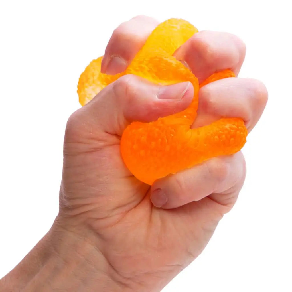 Hand squeezing an orange stress ball against a white background