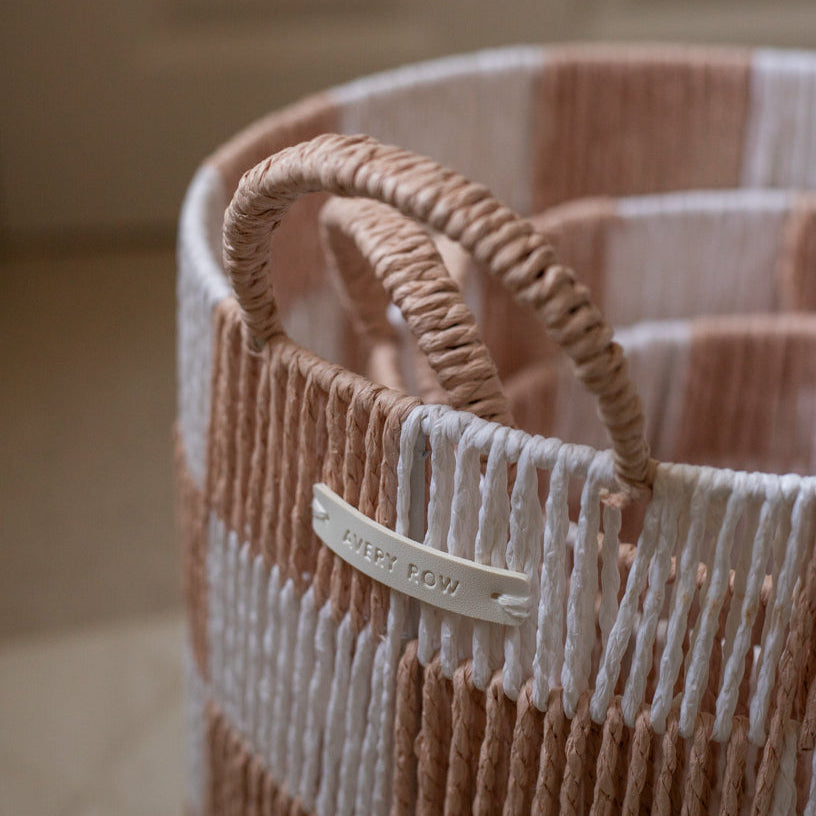 Woven basket with a visible brand tag on a blurred background