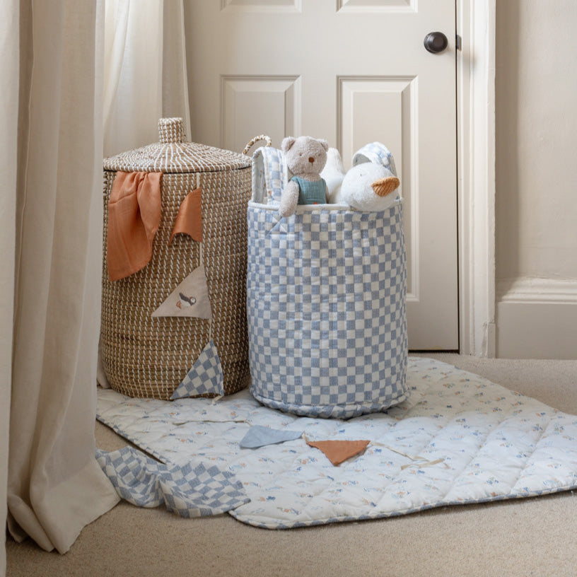Two storage baskets with toys on a carpeted floor in a room.
