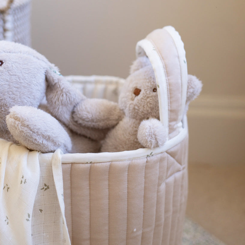 Stuffed teddy bears in a woven basket with a soft focus background