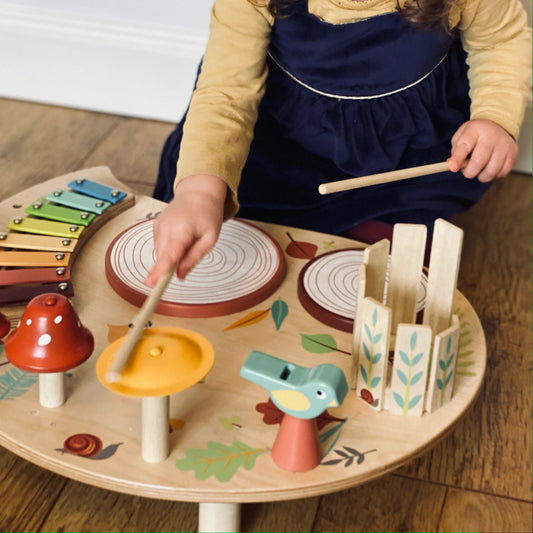 Child playing with a wooden toy set on a wooden floor.