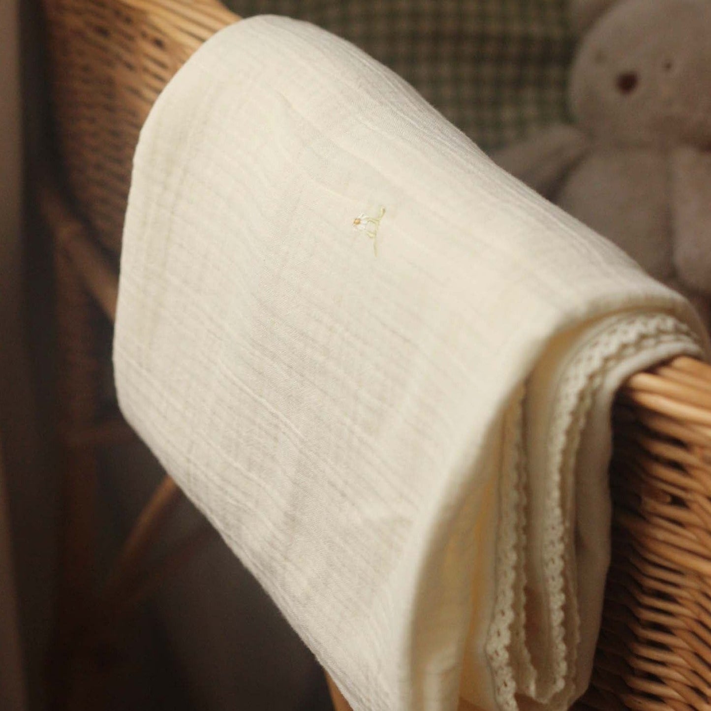 Rolled-up beige towel on a wicker surface