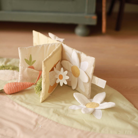 Children's soft book with floral designs on a bed