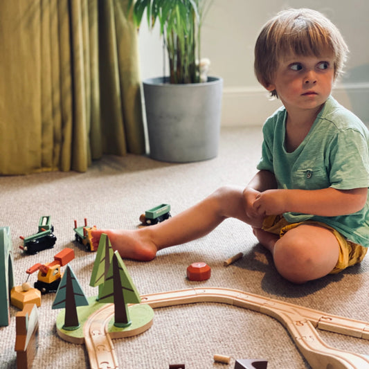 Child playing with wooden train set
