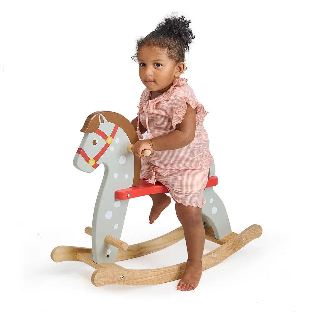Child playing with a rocking horse on a white background