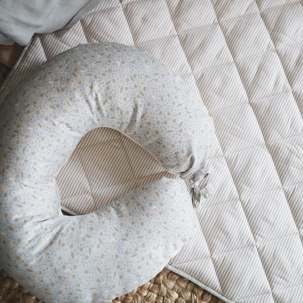 Floral-patterned nursing pillow on a textured surface