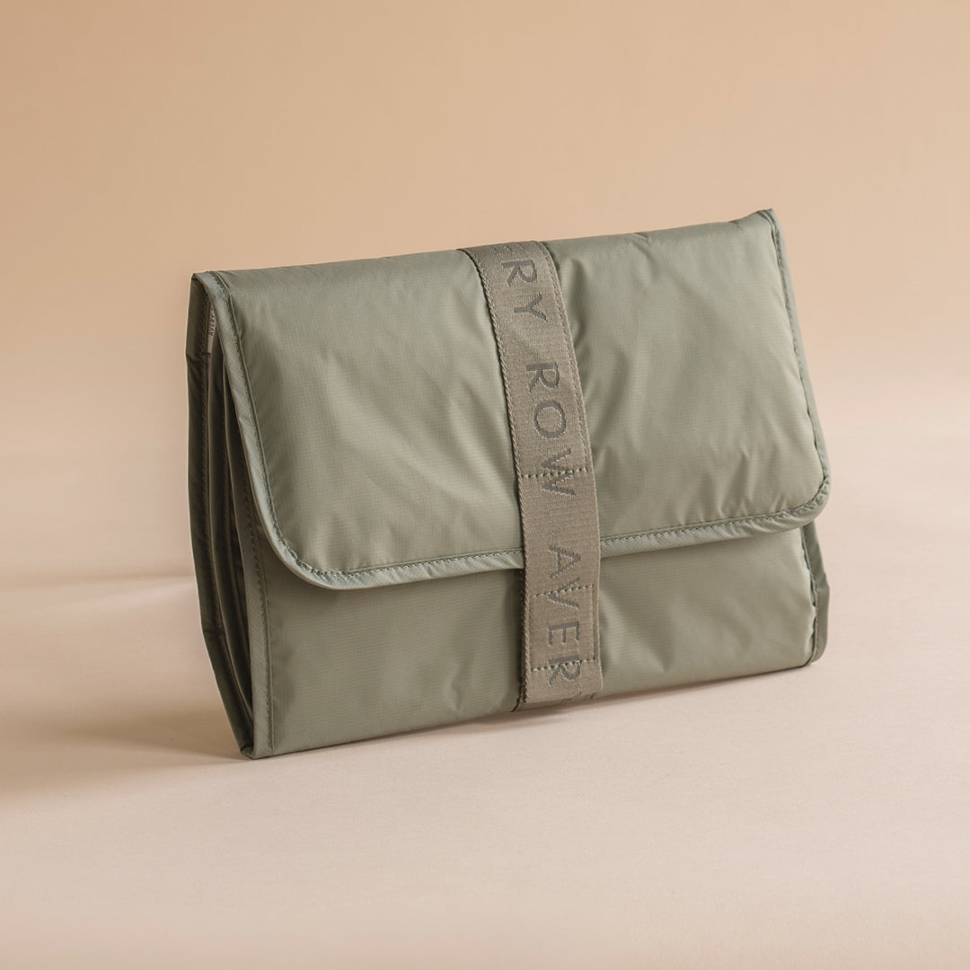 Green toiletry bag with 'Rory Rowan' branding on a beige background
