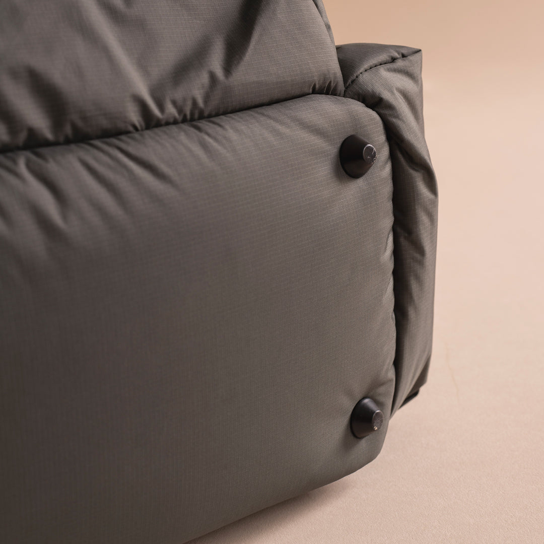 Gray cushion with buttons on a beige background