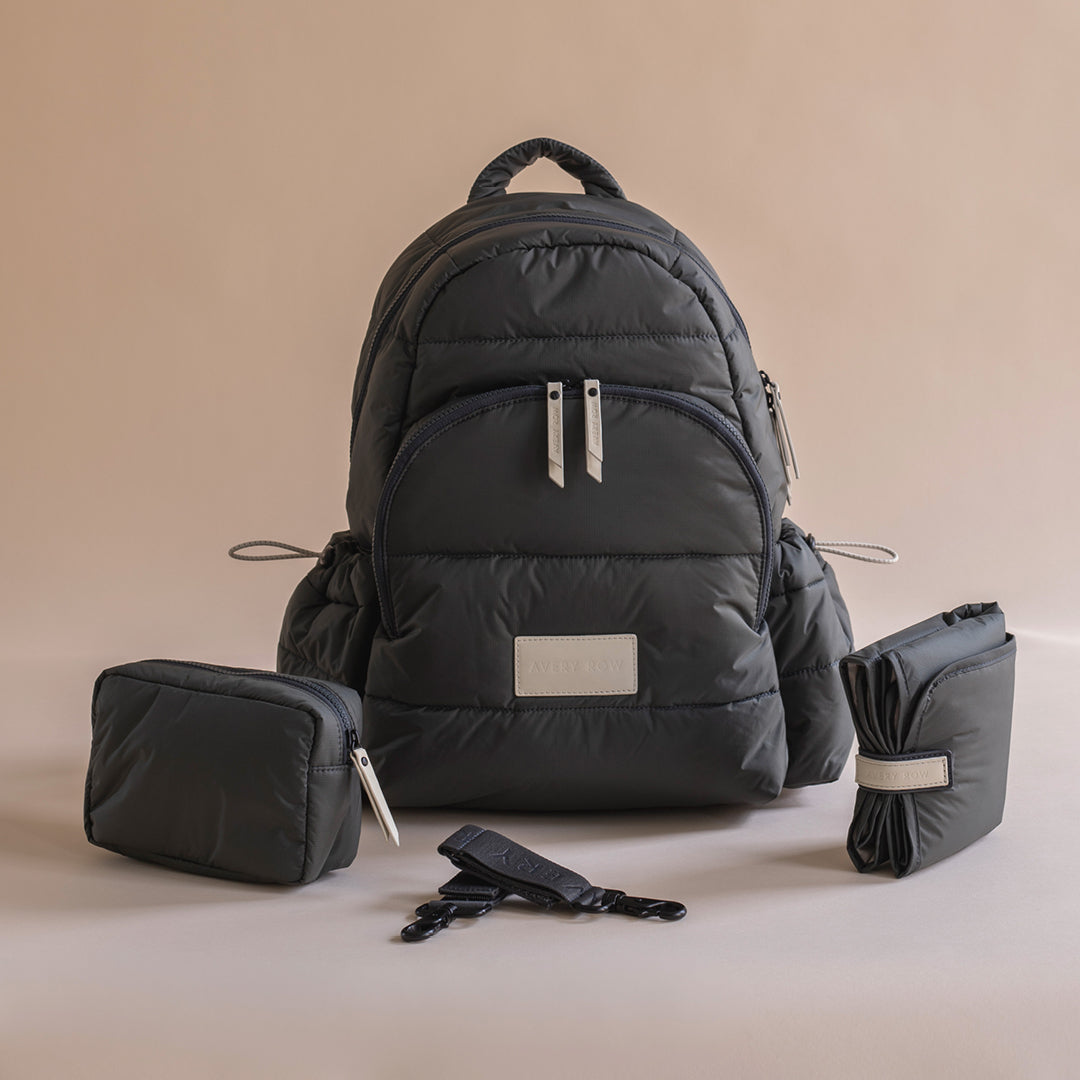 Black backpack with accessories on a beige background