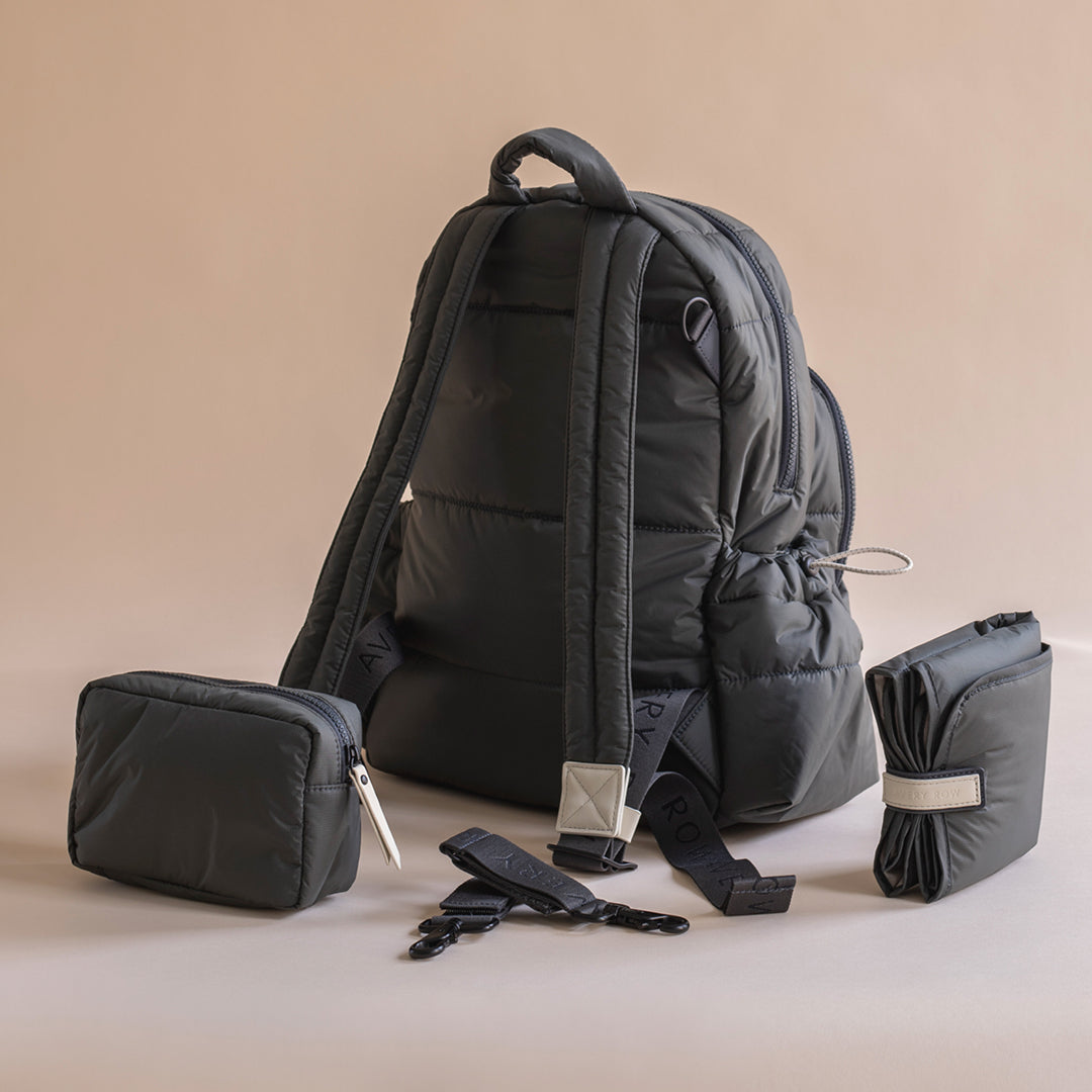 Black backpack with accessories on a beige background
