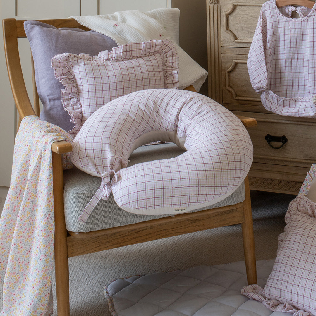 Round pillow with grid pattern on a wooden chair in a home setting