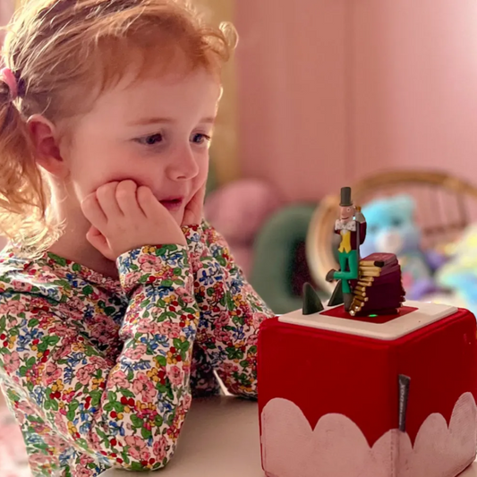 Child playing with a toy music box in a colorful room
