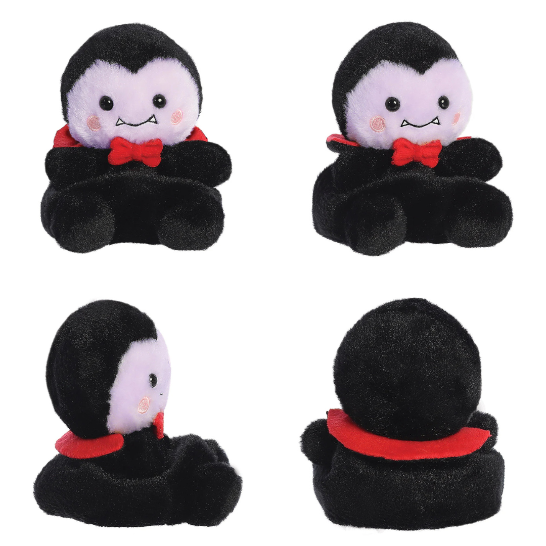 Plush toy with black cape and red bow tie on a white background