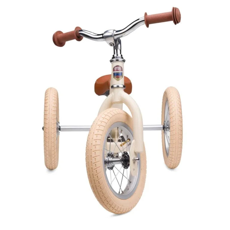 Children's balance bike with beige tires and brown handlebar grips on a white background
