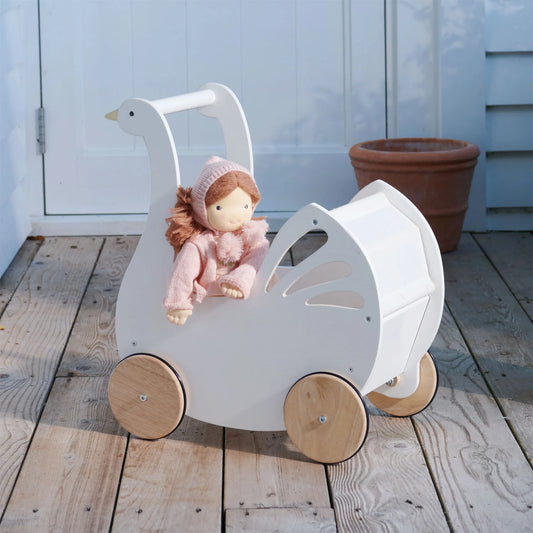 Wooden toy pram with a doll on a wooden floor