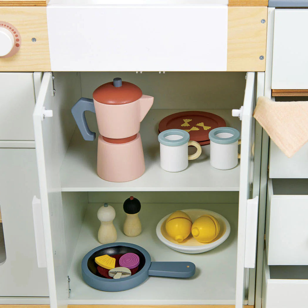 Children's play kitchen set with toy cookware and utensils on a wooden surface.