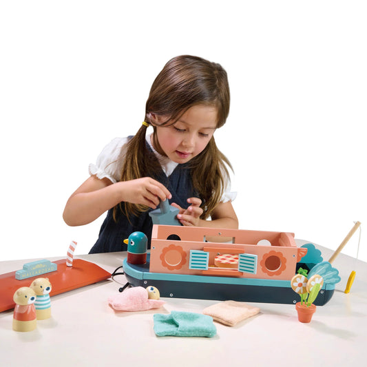 Child playing with a toy boat set on a table