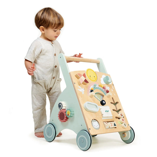 Child playing with a wooden toy push cart on a white background