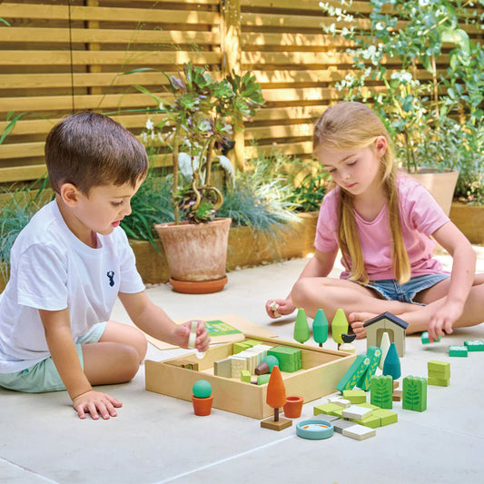 Two children playing with wooden blocks on a patio