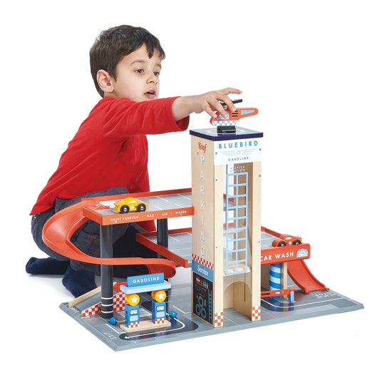 Child playing with a toy car wash set on a white background