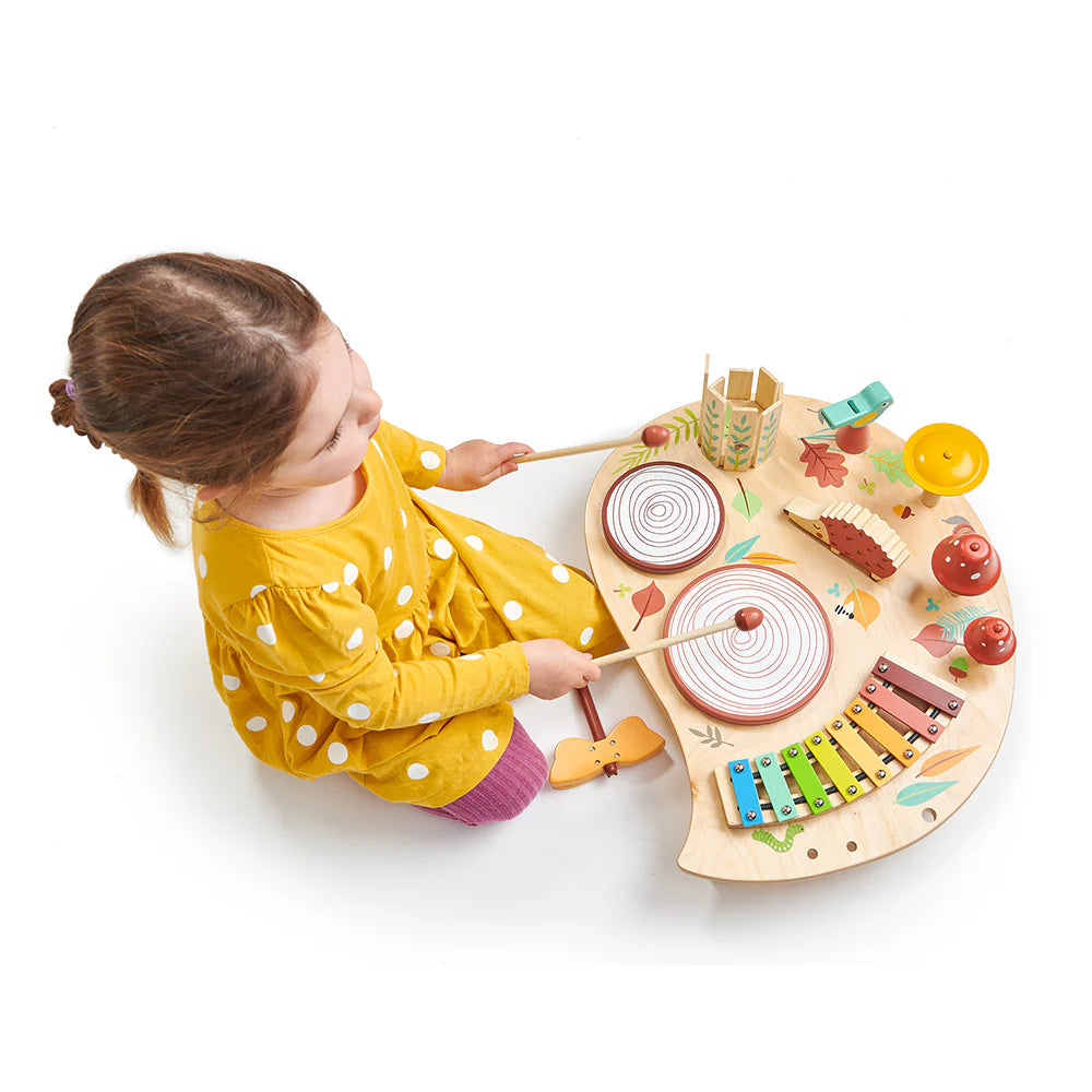 Child playing with a colorful wooden toy piano on a white background