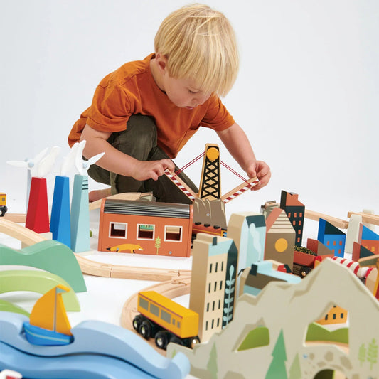 Child playing with a wooden toy set on a white surface