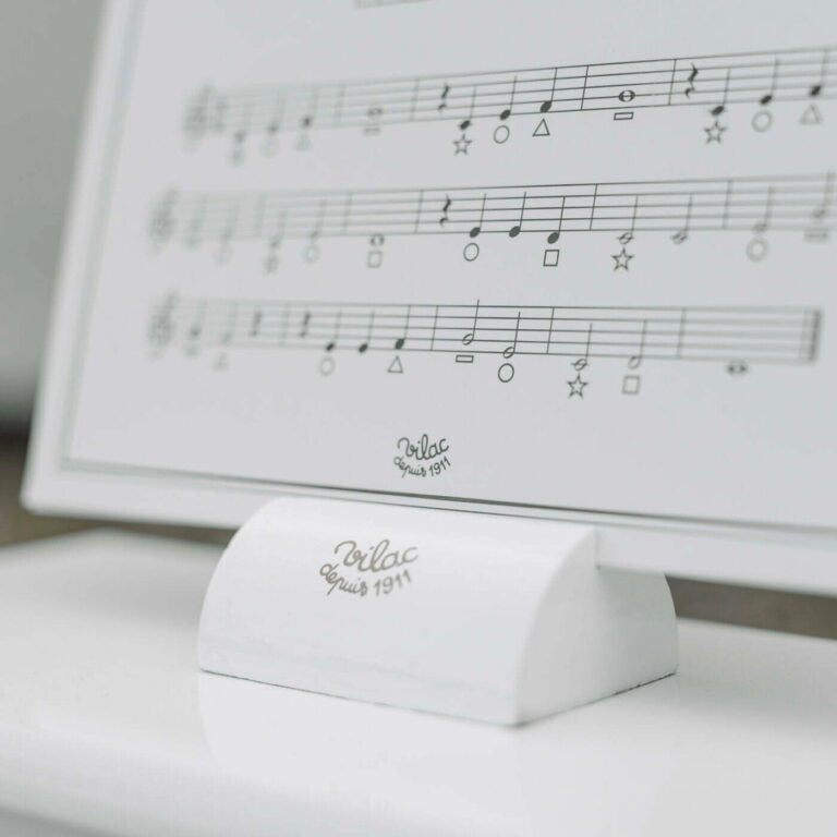 White music stand with sheet music in the background