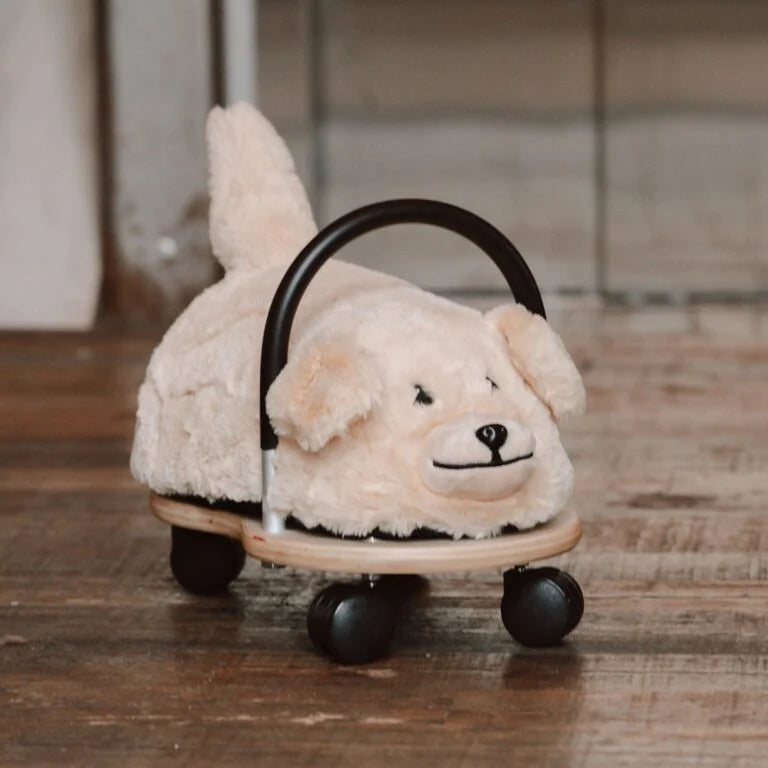 Plush dog toy with wheels on a wooden floor