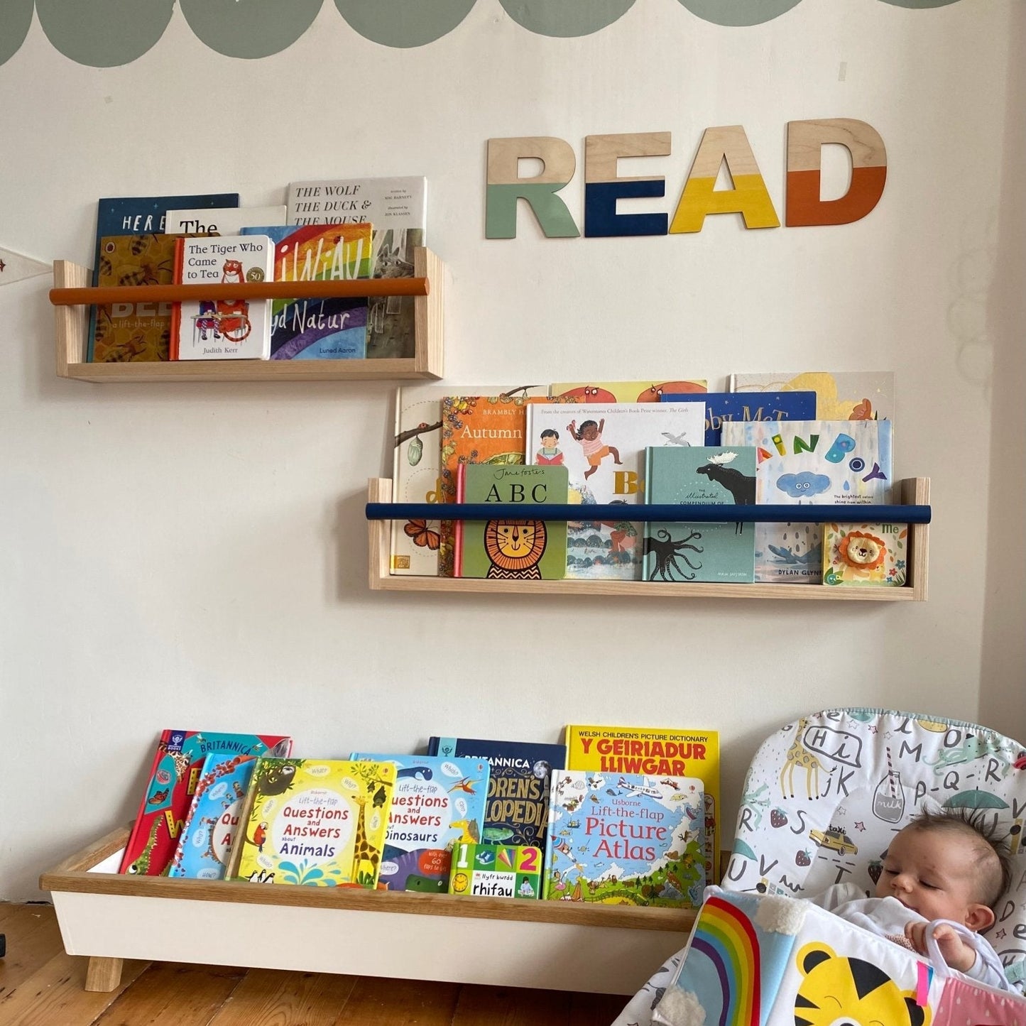 Children's room with bookshelves, books, and a baby in a crib.