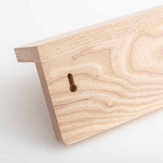 Close-up of a wooden cutting board with a keyhole on a white background