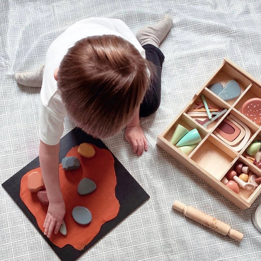 Child playing with wooden toys on a textured floor