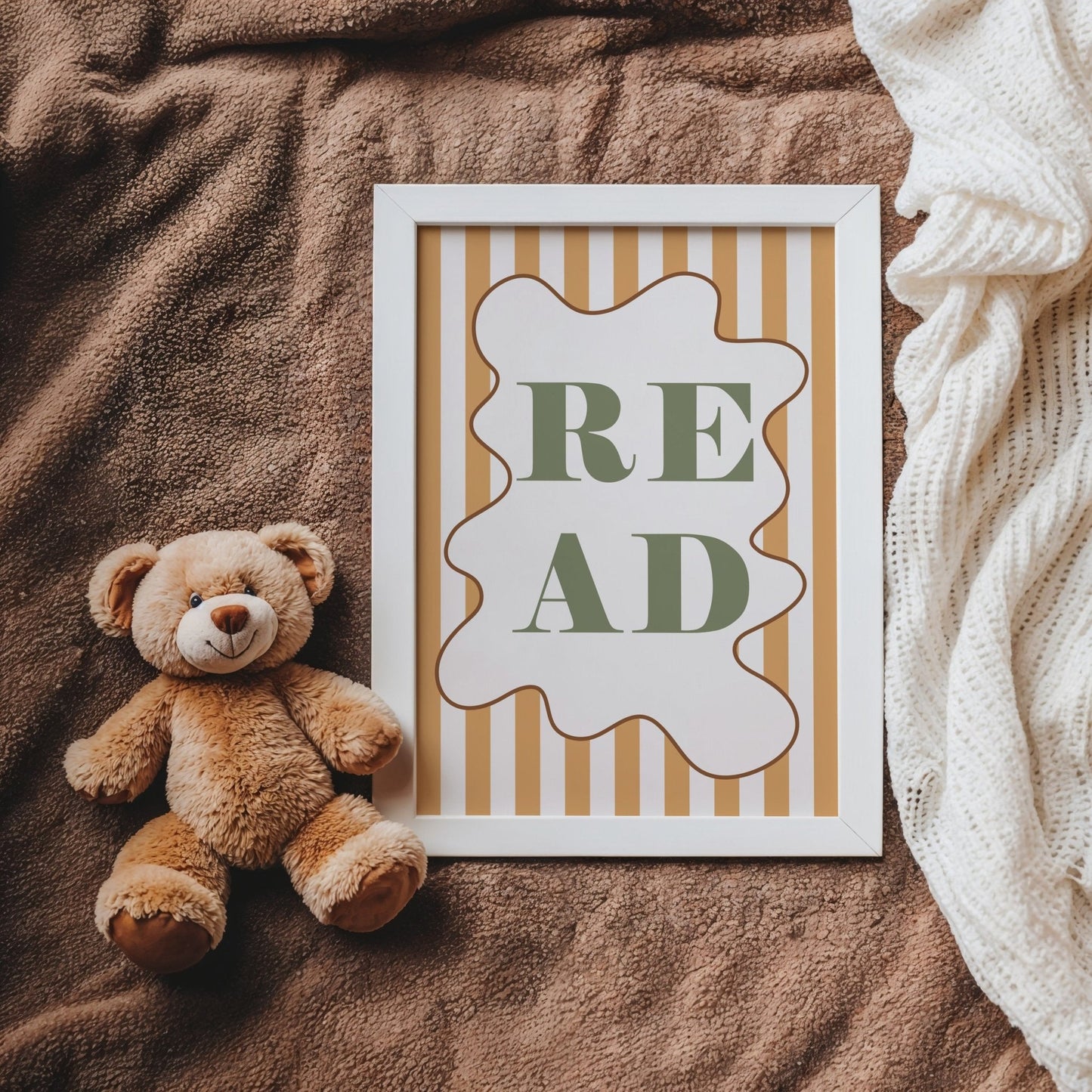 Teddy bear next to a framed picture with 'READ' text on a textured surface