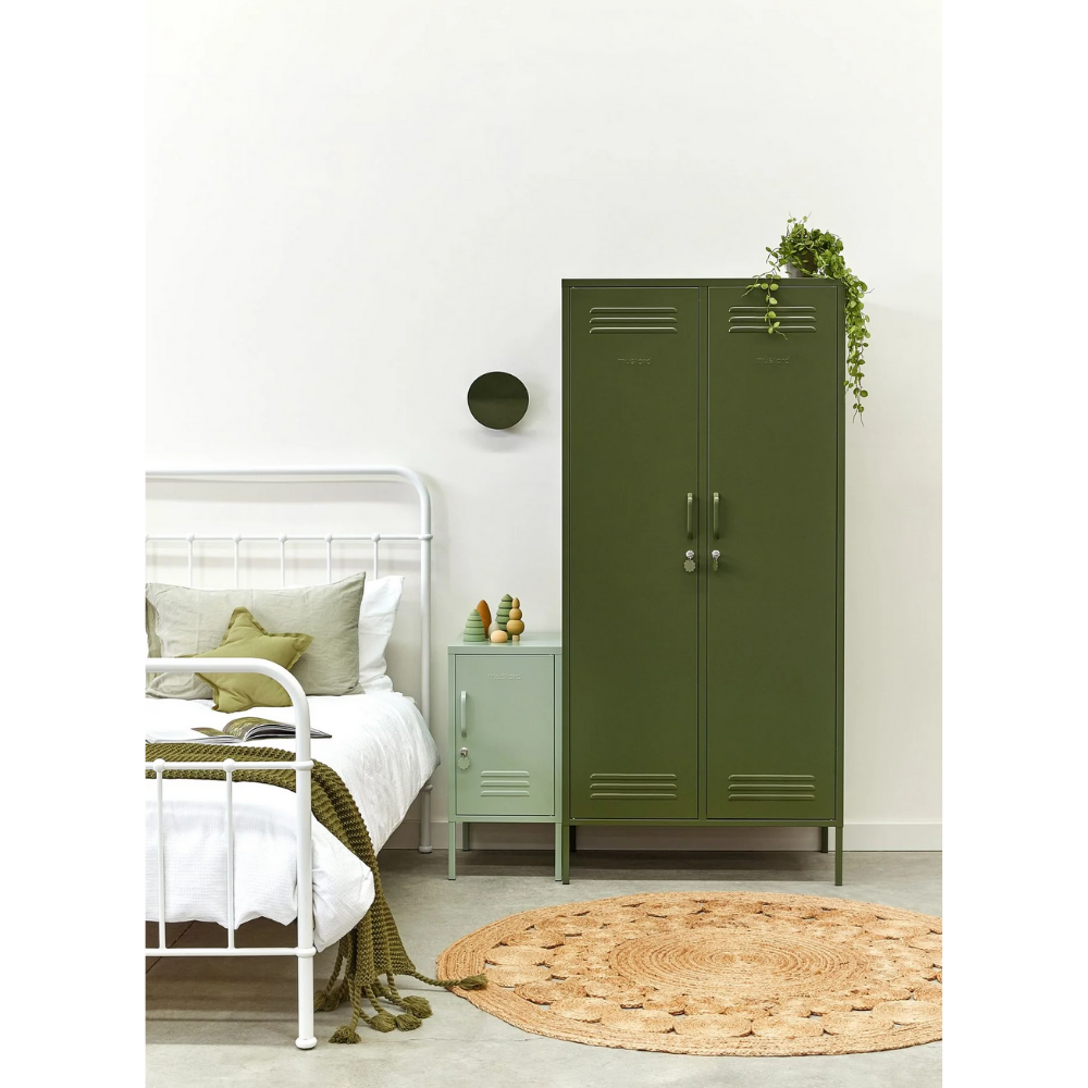 Green metal locker in a bedroom with a bed and nightstand.