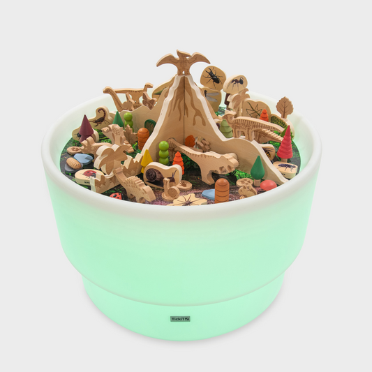 Wooden dinosaur set up a sensory light up table with a wooden volcano