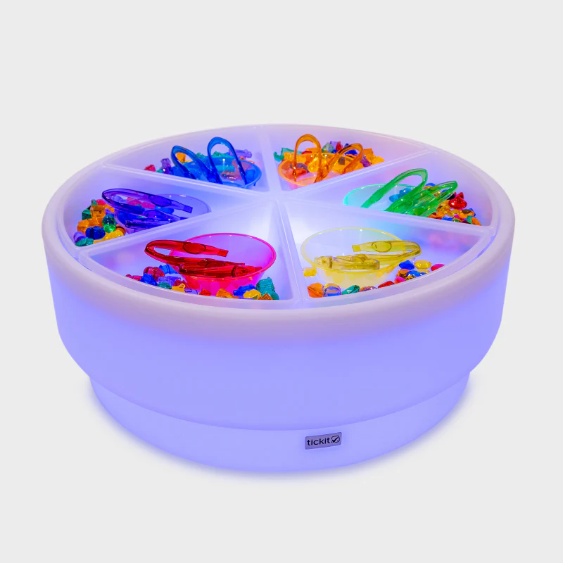 Colorful toy set in a round, segmented container with LED lighting on a white background