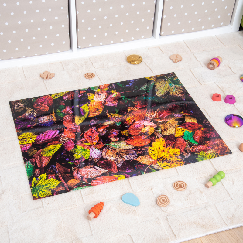 Colorful leaf-patterned mat on a light wooden floor with toys around